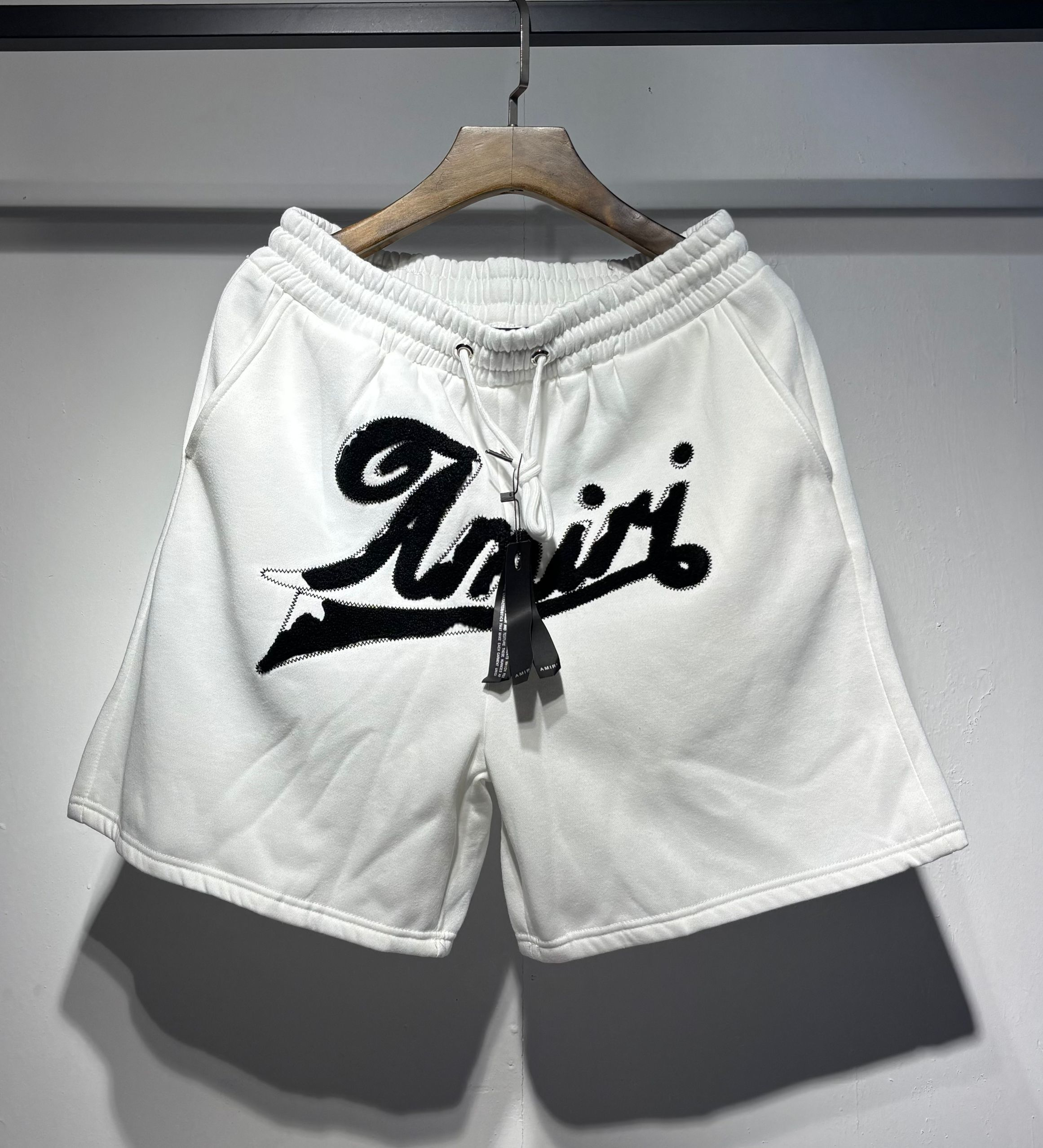 White graffiti-style printed and outlined logo shorts