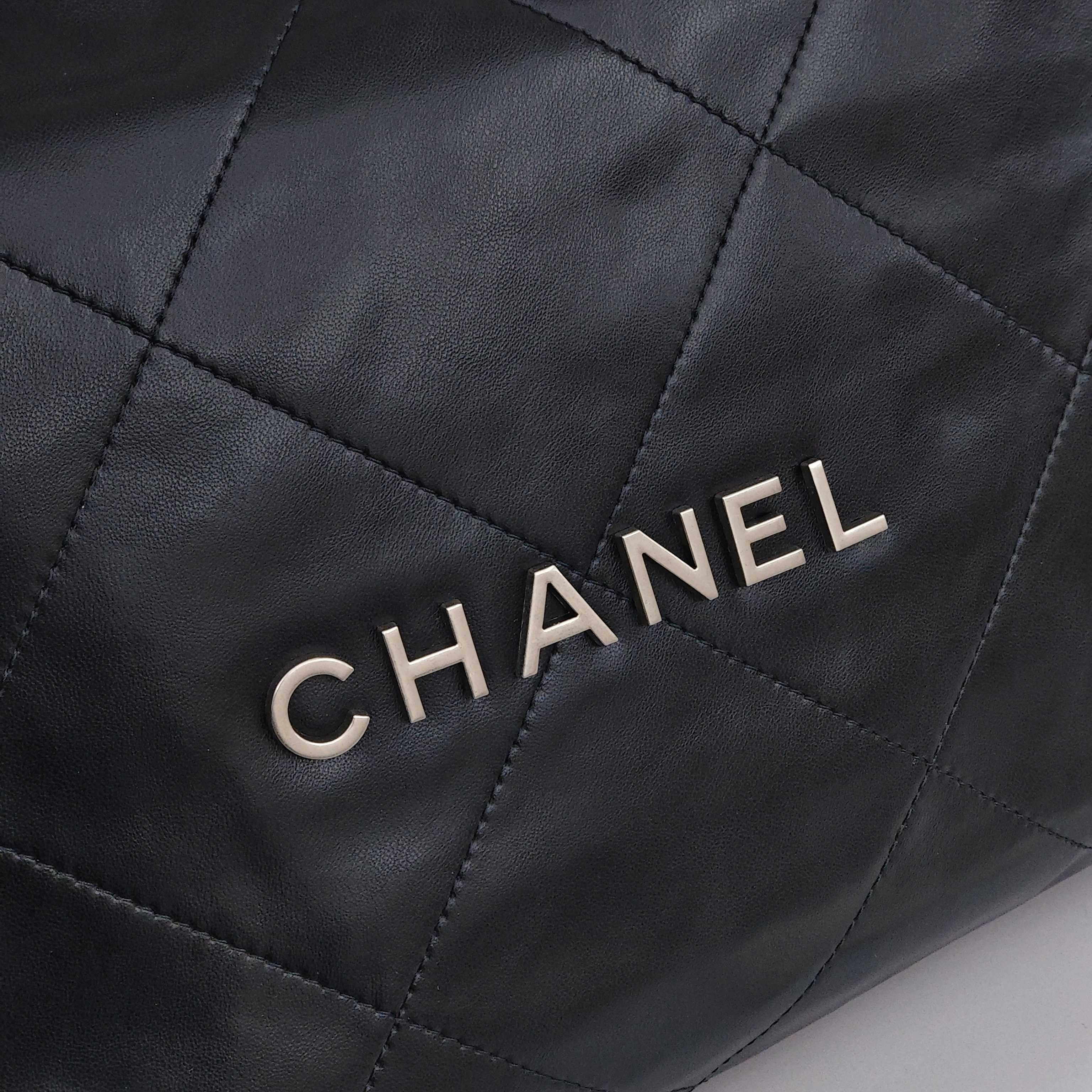 CHANEL 22 Bag Mini. With silver logo, diamond check pattern and drawstring. Made of calfskin. Bucket bag. Can be carried as a crossbody bag or a shoulder bag. Mini size. For women. In black.