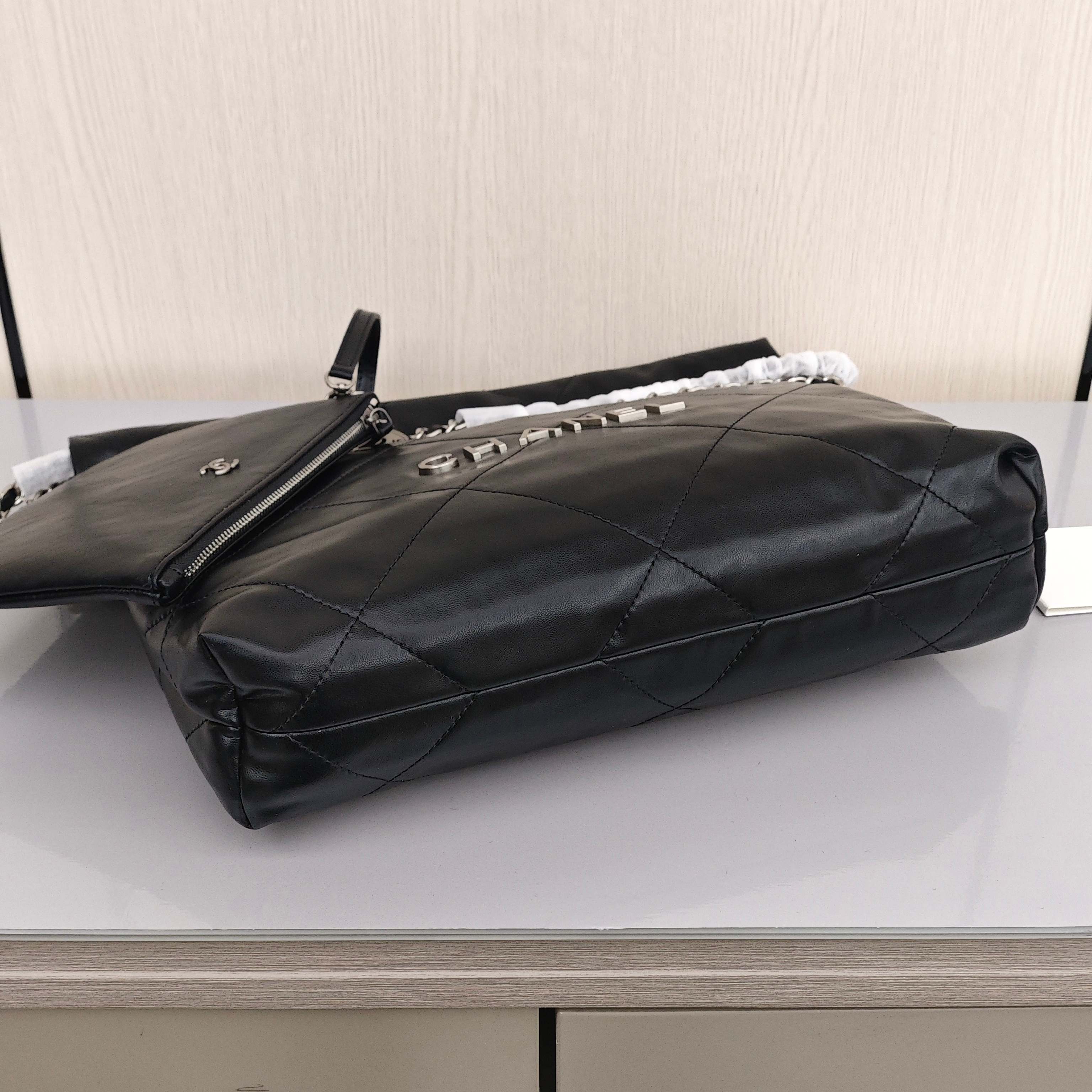 CHANEL 22 Bag Mini. With silver logo, diamond check pattern and drawstring. Made of calfskin. Bucket bag. Can be carried as a crossbody bag or a shoulder bag. Mini size. For women. In black.