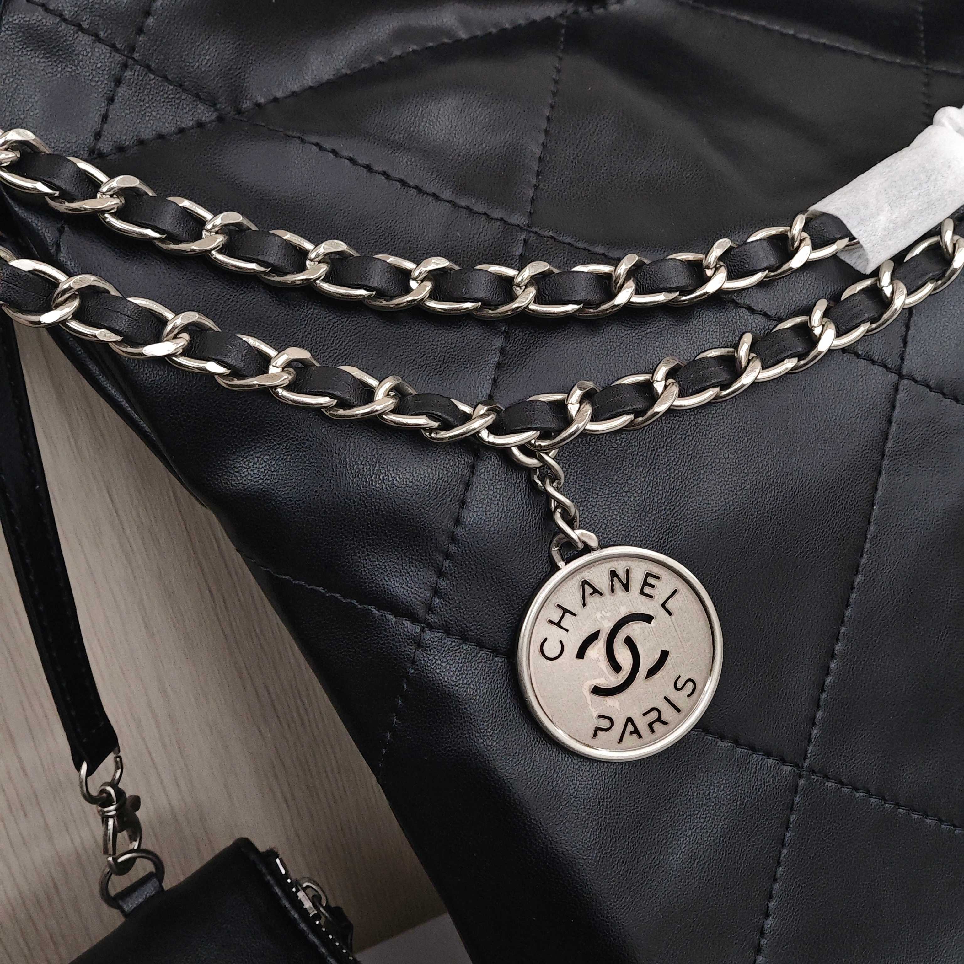 CHANEL 22 Bag Mini. With silver logo, diamond check pattern and drawstring. Made of calfskin. Bucket bag. Can be carried as a crossbody bag or a shoulder bag. Mini size. For women. In black.