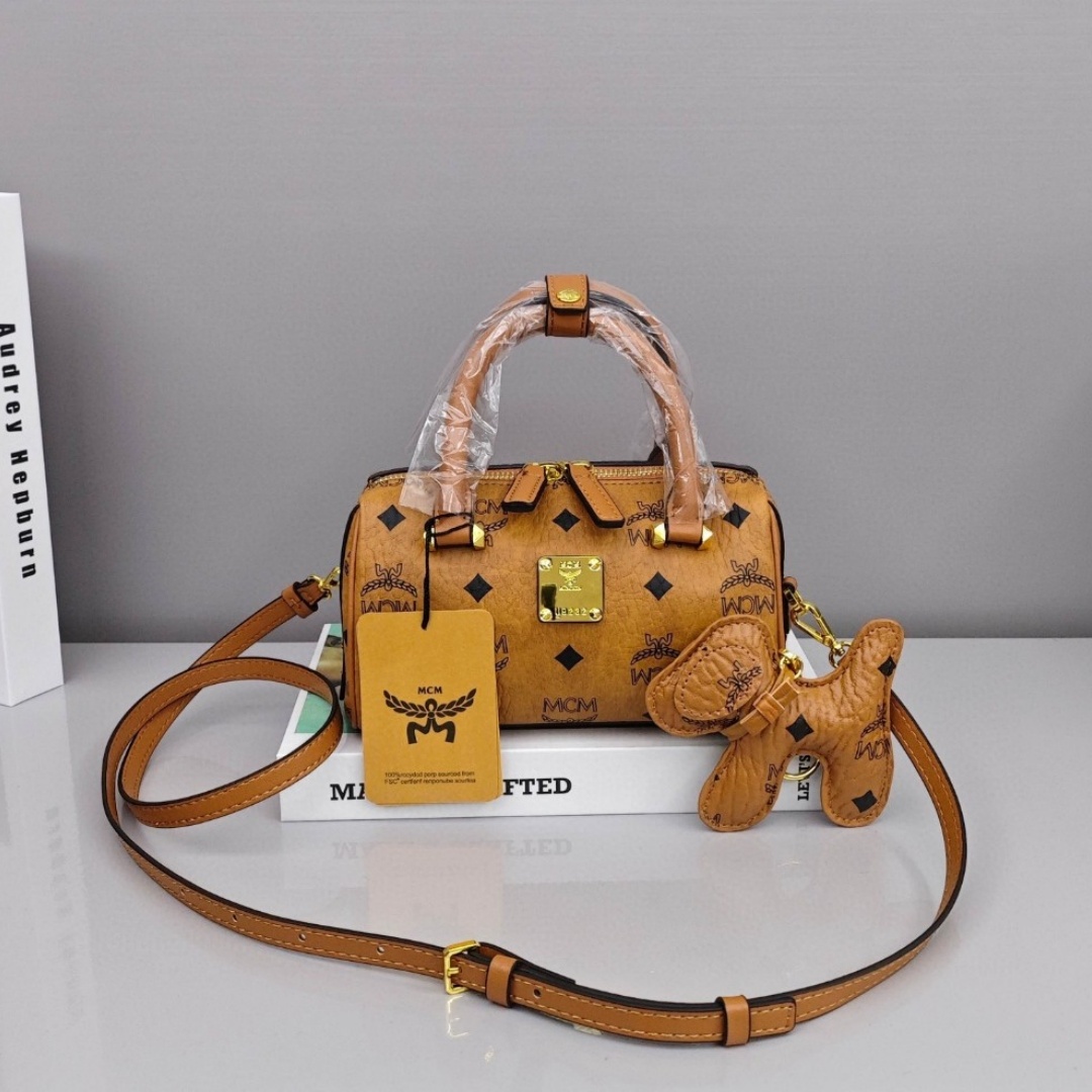 MCM Aren Original Visetos Boston Bag with Leather Trim. Can be carried by hand, worn crossbody or on the shoulder. Unisex Style. Brown.