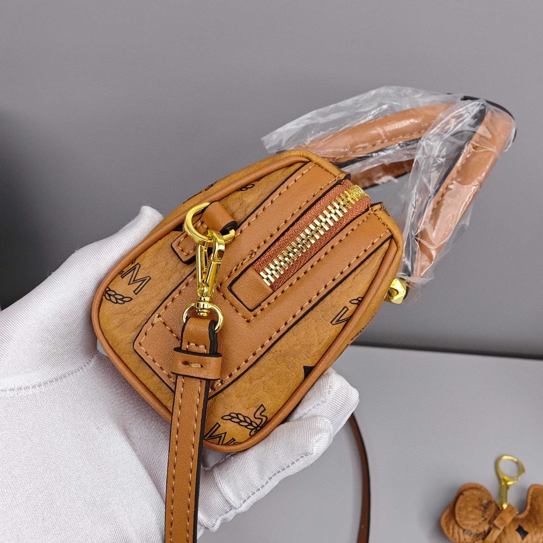 MCM Aren Original Visetos Boston Bag with Leather Trim. Can be carried by hand, worn crossbody or on the shoulder. Unisex Style. Brown.