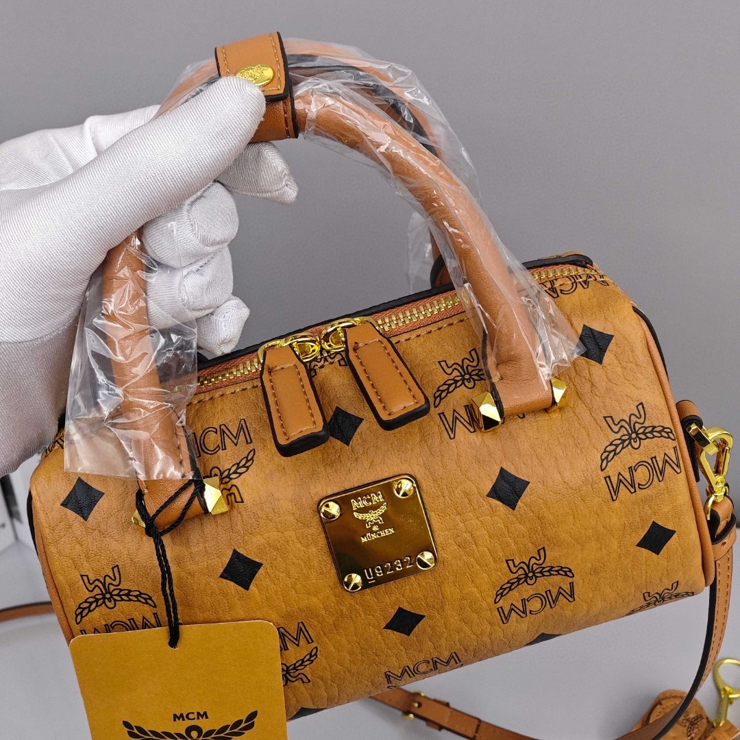 MCM Aren Original Visetos Boston Bag with Leather Trim. Can be carried by hand, worn crossbody or on the shoulder. Unisex Style. Brown.