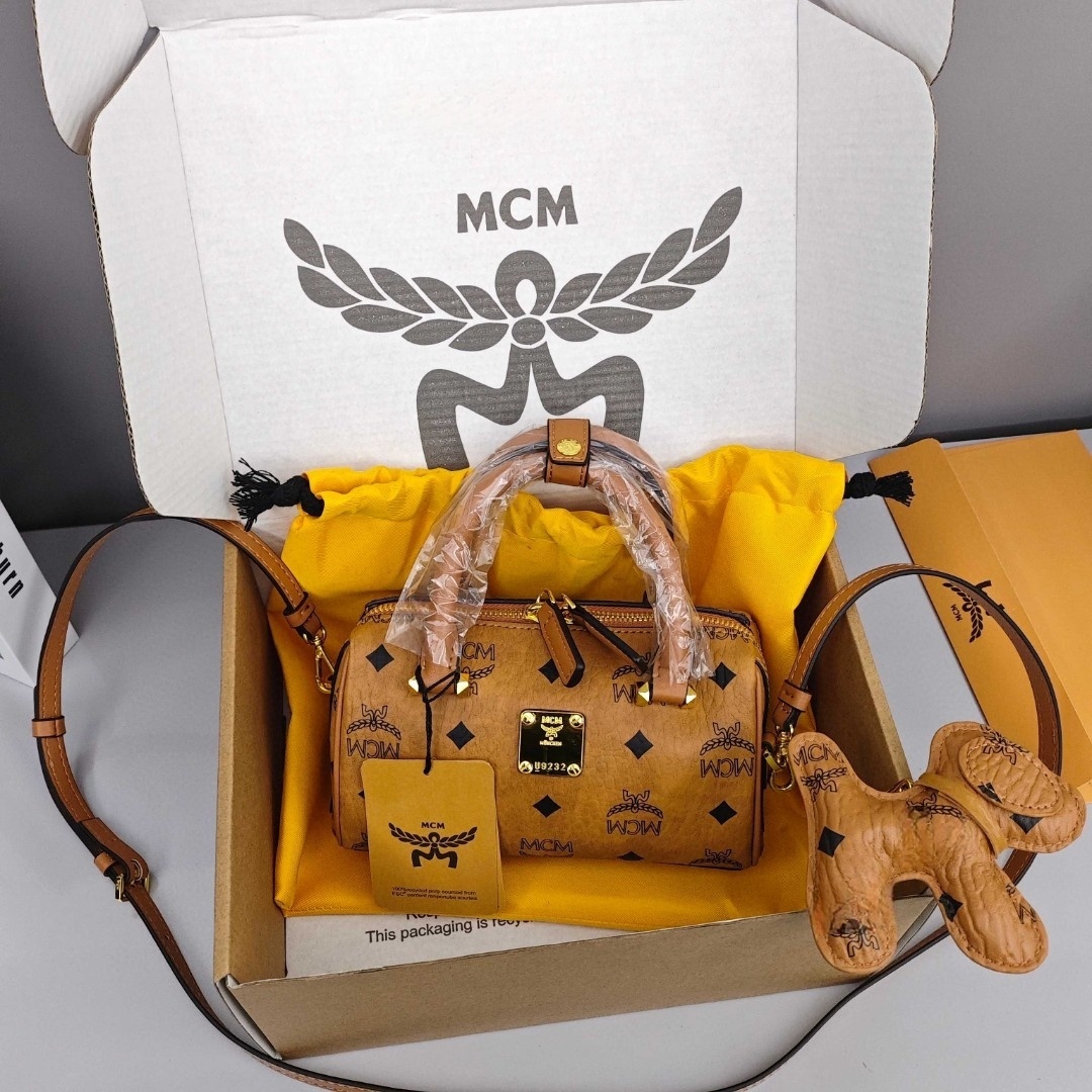 MCM Aren Original Visetos Boston Bag with Leather Trim. Can be carried by hand, worn crossbody or on the shoulder. Unisex Style. Brown.