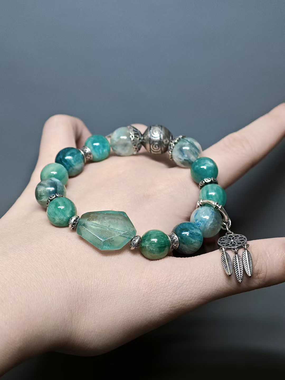 Turquoise waves rock green reflections,White egrets skim the cool shallows.Distant peaks hold misty verdure,A light boat drifts into the painted scene.