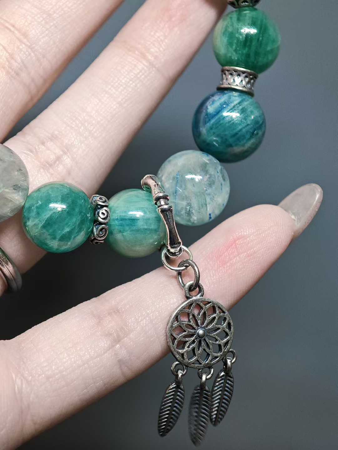 Turquoise waves rock green reflections,White egrets skim the cool shallows.Distant peaks hold misty verdure,A light boat drifts into the painted scene.