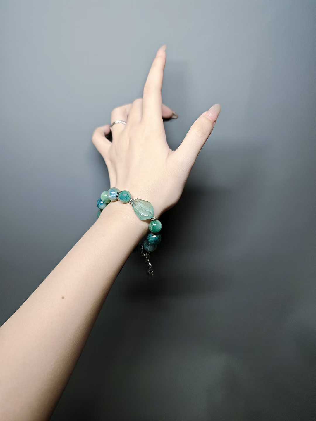 Turquoise waves rock green reflections,White egrets skim the cool shallows.Distant peaks hold misty verdure,A light boat drifts into the painted scene.