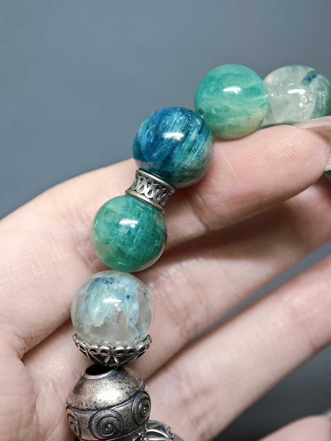 Turquoise waves rock green reflections,White egrets skim the cool shallows.Distant peaks hold misty verdure,A light boat drifts into the painted scene.