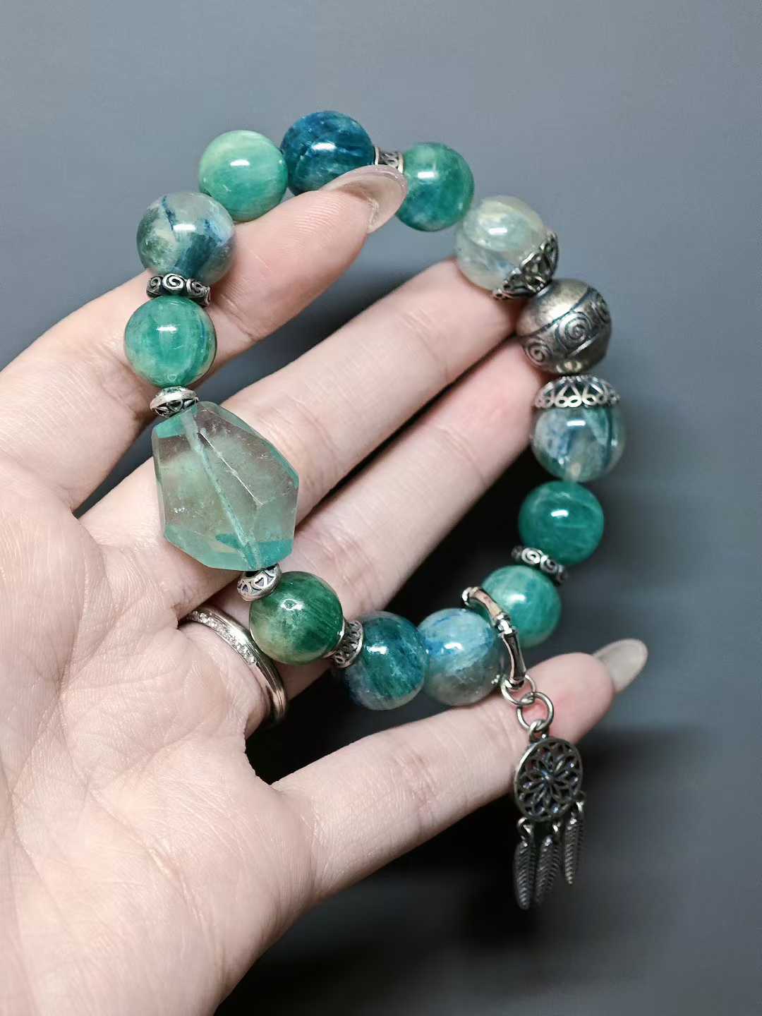 Turquoise waves rock green reflections,White egrets skim the cool shallows.Distant peaks hold misty verdure,A light boat drifts into the painted scene.