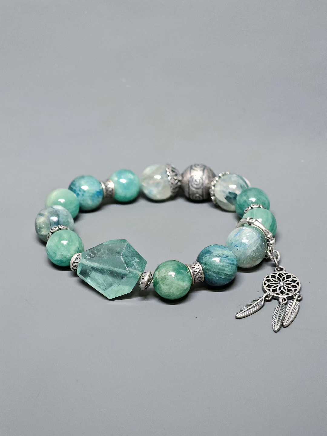 Turquoise waves rock green reflections,White egrets skim the cool shallows.Distant peaks hold misty verdure,A light boat drifts into the painted scene.